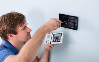 Capsis security worker fixing alarm system